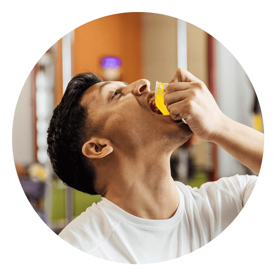 Man taking a pre-workout shot for an energy boost at the gym.
